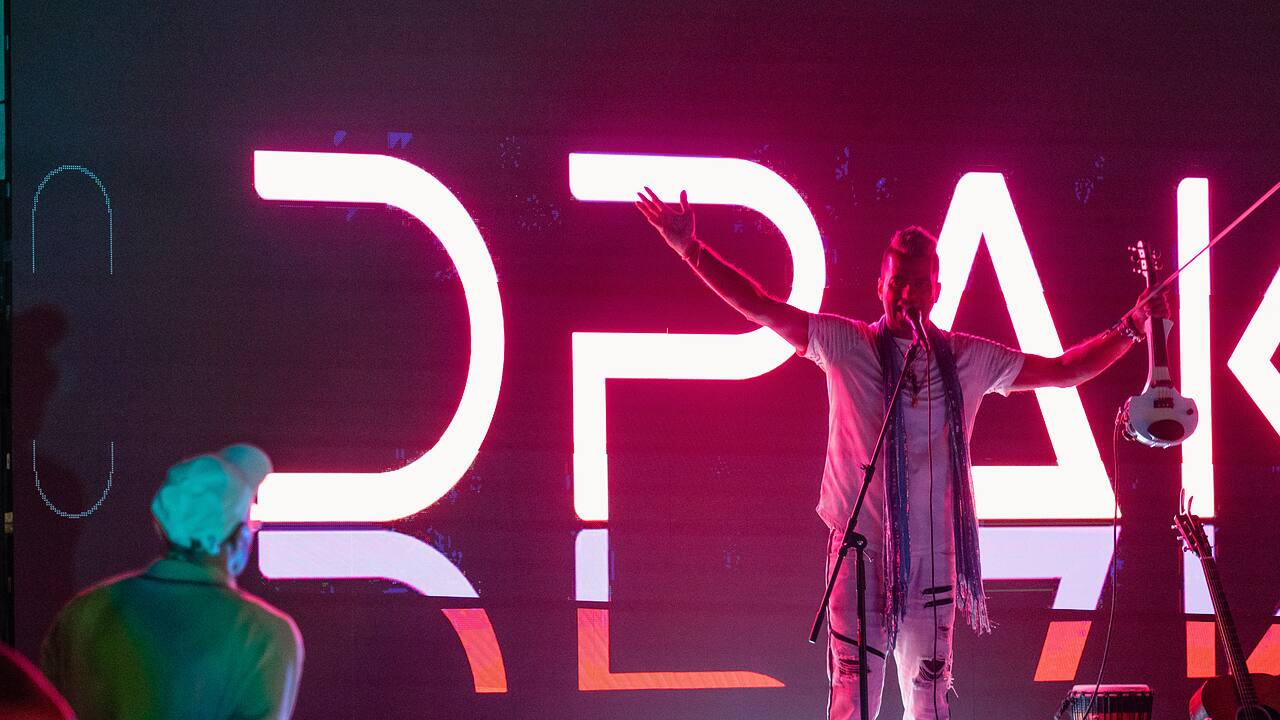 A performer on a lit stage during the evening programme