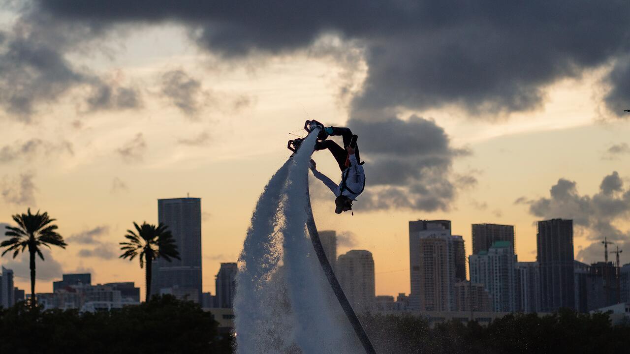 A flyboarder over the bay at dusk against the Miami skyline