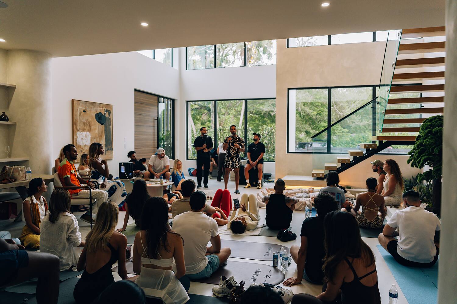 A villa living room filled with guests seated for a session